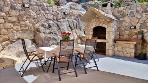 a table and chairs in front of a stone oven at Apartment Vise - Old Town Center, Stone Terrace in Omiš