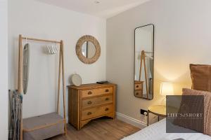 a bedroom with a bed and a dresser and a mirror at 11 Friernhay Court in Exeter