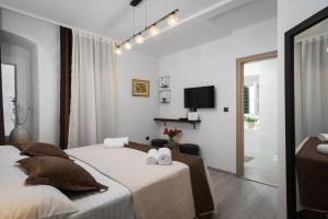 a white bedroom with a bed and a tv at Palace Penthouse with Terrace in Split Centre Old Town in Split
