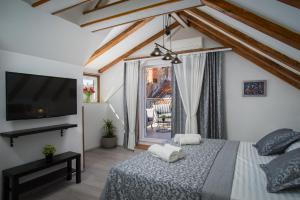 a bedroom with a bed with a tv and a balcony at Palace Penthouse with Terrace in Split Centre Old Town in Split