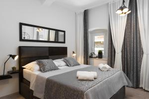a bedroom with a large bed and a mirror at Palace Penthouse with Terrace in Split Centre Old Town in Split