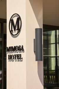 ein Schild für ein Maserati-Hotel an der Seite eines Gebäudes in der Unterkunft Mimosa Hotel in Westerland