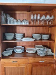 un armario de madera lleno de platos y platos en Villa Mila, en Dalung
