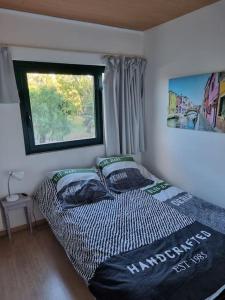 een slaapkamer met een bed met 2 kussens en een raam bij Superbe Appartement Avec Magnifique Vue sur La mer in Saint-Cyprien