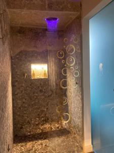 La salle de bains est pourvue d'une douche en verre avec un plafond violet. dans l'établissement Love Space Sensory Spa & relax suite, à Santa Maria delle Mole