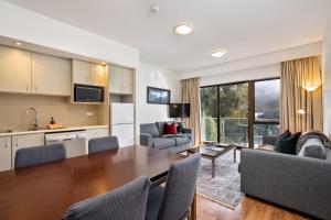 a kitchen and living room with a table and chairs at Lantern 1 Bedroom Balcony with amazing view in Thredbo