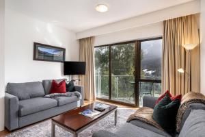 a living room with a couch and a table at Lantern 1 Bedroom Balcony with amazing view in Thredbo