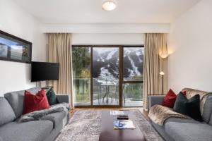 a living room with two couches and a large window at Lantern 1 Bedroom Balcony with amazing view in Thredbo