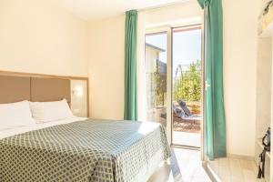 um quarto com uma cama e uma porta de vidro deslizante em Verde Coccola - Casa Vacanze em Ospedaletto dʼAlpinolo