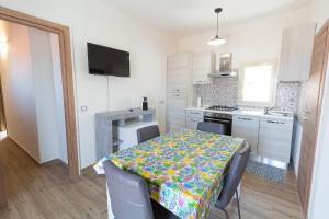 une cuisine avec une table et un tissu de table coloré. dans l'établissement Apartment Lo Duca, à Cefalù