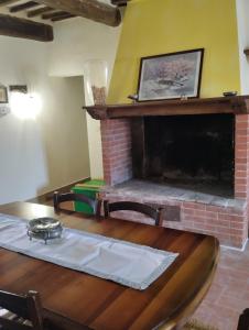 een woonkamer met een open haard en een houten tafel bij ROSMARINO CASALE in Città della Pieve