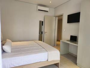 a white bedroom with a bed and a television at Soleia 3 in Mauritius in Grand Baie