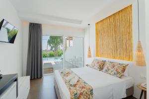 a hotel room with a bed and a tv at Belmare Hotel-Adults Οnly in Lartos