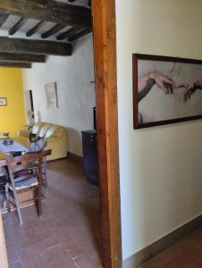 una sala de estar con una mesa y una pintura en la pared en ROSMARINO CASALE en Città della Pieve
