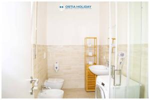 un bagno con due lavandini, un water e una doccia di Tristano e Isotta a Lido di Ostia Altre 19 foto