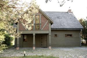 a house with a garage with a roof at Dom Nad Jeziorem - Rydzewo in Rydzewo