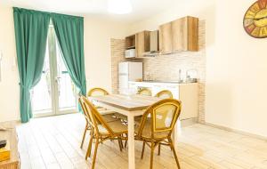 uma cozinha e sala de jantar com mesa e cadeiras em Verde Coccola - Casa Vacanze em Ospedaletto dʼAlpinolo