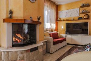 a living room with a fireplace and a tv at Villa Lolù in Terranuova Bracciolini