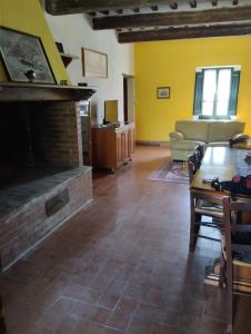 a living room with a brick fireplace and a table at ROSMARINO CASALE in Città della Pieve