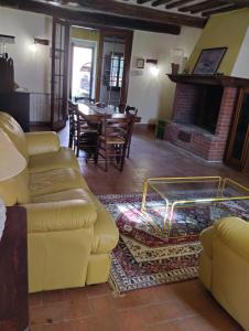 salon z żółtą kanapą i stołem w obiekcie ROSMARINO CASALE w mieście Città della Pieve