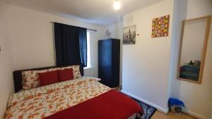 een slaapkamer met een bed met een rode deken bij Comfortable Host, in zone 2-3 in Londen
