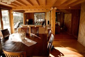 a dining room with a wooden table and chairs at Dom Nad Jeziorem - Rydzewo in Rydzewo