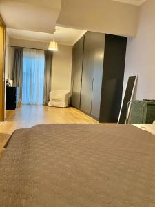 ein Schlafzimmer mit einem Bett und ein Zimmer mit einem Fenster in der Unterkunft Eleusis luxury flat in Eleusis