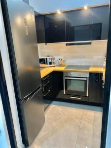 a kitchen with a stainless steel refrigerator and a stove at Eleusis luxury flat in Elefsina