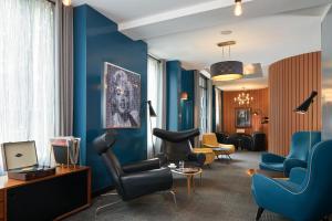 パリにあるプラチヌ ホテルの青い壁と椅子が備わるリビングルーム