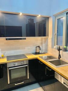 a kitchen with a counter and a sink and a stove at Eleusis luxury flat in Elefsina