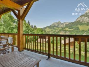 a wooden porch with a bench and mountains in the background at Appartement Le Grand-Bornand, 2 pièces, 4 personnes - FR-1-391-107 in Le Grand-Bornand