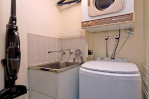 a small bathroom with a sink and a microwave at Lantern 18 Balcony in Thredbo
