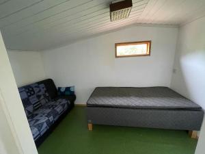 Habitación con 2 camas y sofá. en 3 bedroom lakehouse with private bridge and garden, en Sundsvall