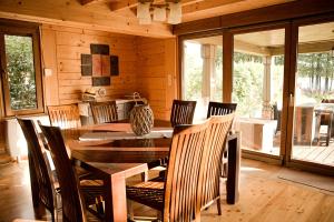 a dining room with a table and chairs in a cabin at Dom Nad Jeziorem - Rydzewo in Rydzewo +23 photos