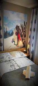 ザコパネにあるHosana Zakopane Pokoje Gościnne i Apartamentyのベッドルーム1室(壁に絵画が描かれたベッド1台付)