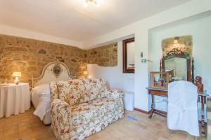 ein Schlafzimmer mit einem Sofa, einem Bett und einem Spiegel in der Unterkunft Villa Olmo With Private Pool in Castel di Lucio