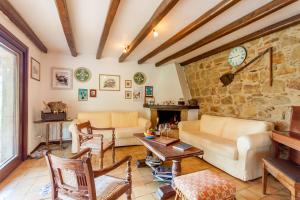 ein Wohnzimmer mit einem Sofa und einer Steinmauer in der Unterkunft Villa Olmo With Private Pool in Castel di Lucio