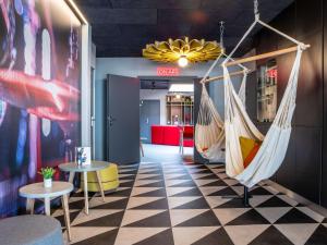a lobby with two hammocks and tables in a room at ibis Compiegne in Compiègne