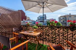 a table and chairs with an umbrella on a balcony at Covelo Park Apartment in Porto