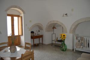 salon z łukami, stołem i krzesłami w obiekcie Trullo Pugliese w Alberobello +11 zdjęć
