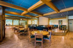 uma sala de jantar com mesas e cadeiras de madeira em Best Western Prairie Inn & Conference Center em Galesburg