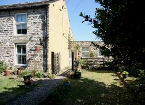 an old stone house with a garden in front of it at Holmlea in Mickleton