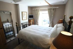 a bedroom with a bed and a mirror and a window at Holmlea in Mickleton