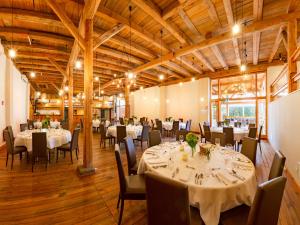 a dining room with tables and chairs and wooden ceilings at ACANTUS Hotel in Weisendorf