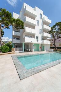 an apartment with a swimming pool in front of a building at Apartaments Andreas in Colònia de Sant Jordi