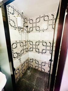 a bathroom with a shower with white and black tiles at HomeStay Inn in Suva