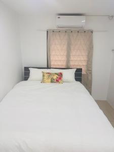 a white bed with two pillows on top of it at HomeStay Inn in Suva