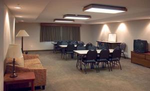 uma sala de conferências com mesas e cadeiras e uma televisão em AmericInn by Wyndham Charlevoix em Charlevoix
