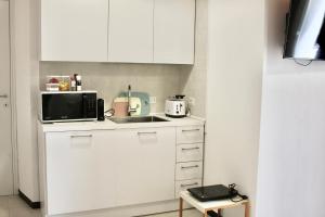 a white kitchen with a sink and a microwave at VIA CAVOUR 12 in Portoscuso