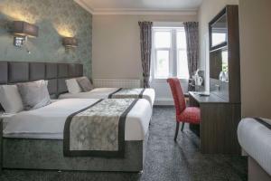 a hotel room with two beds and a desk at Sure Hotel by Best Western Lockerbie in Lockerbie